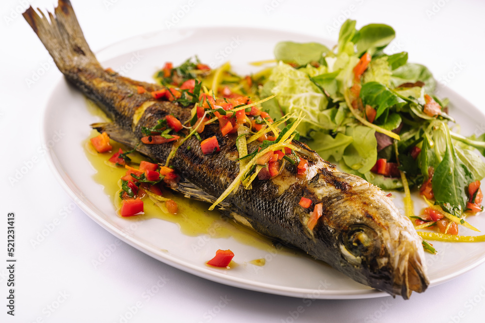 Grilled fish with vegetables on white plate Grilled fish with vegetables on white plate