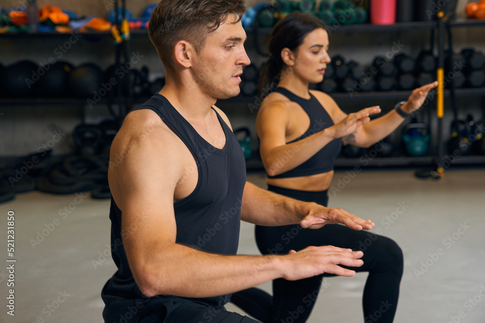 Sporty woman and man doing lunges with together at the fitness club Sporty woman and man doing lunges with together at the fitness club