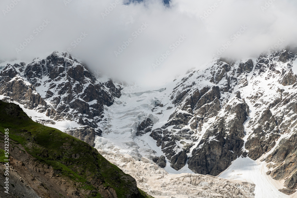 Beautiful alpian mountains landscape in the clouds. Amazing close-up view on the glacier.