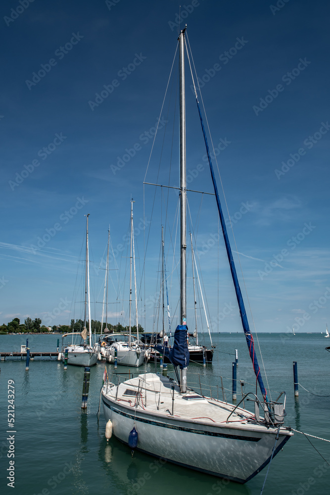 Modern Sail Boat Anchors In Calm Harbor On Lake Balaton In Hungary Modern Sail Boat Anchors In Calm Harbor On Lake Balaton In Hungary