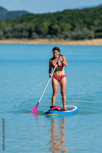 Woman Paddle Surfing on Lake Montbel in Ariege with the boats in the summer of 2022 © martinscphoto