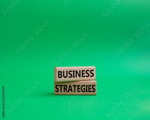Business strategies symbol. Concept words Business strategies on wooden blocks. Beautiful green background. Business and Business strategies concept. Copy space.