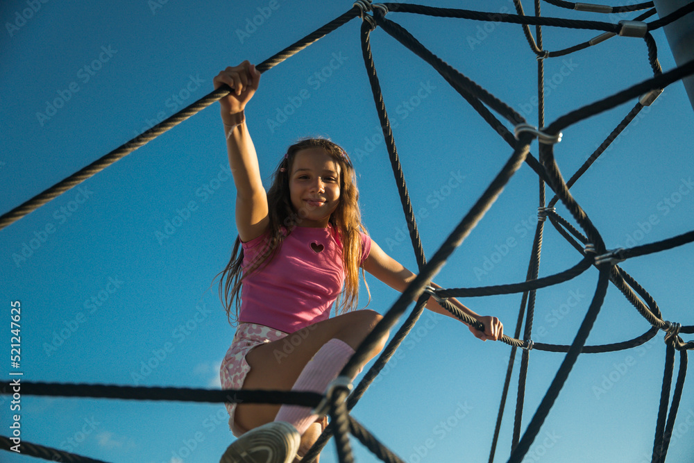 Active teen child playing at the open air playground while spending time alone Active teen child playing at the open air playground while spending time alone