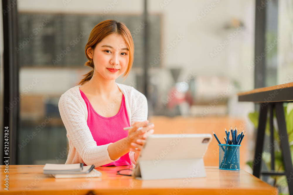 Happy Asian female student wearing headphones, studying online, watching webinars, podcasts on tablets, listening, learning, education courses. online meeting Happy Asian female student wearing headphones, studying online, watching webinars, podcasts on tablets, listening, learning, education courses. online meeting