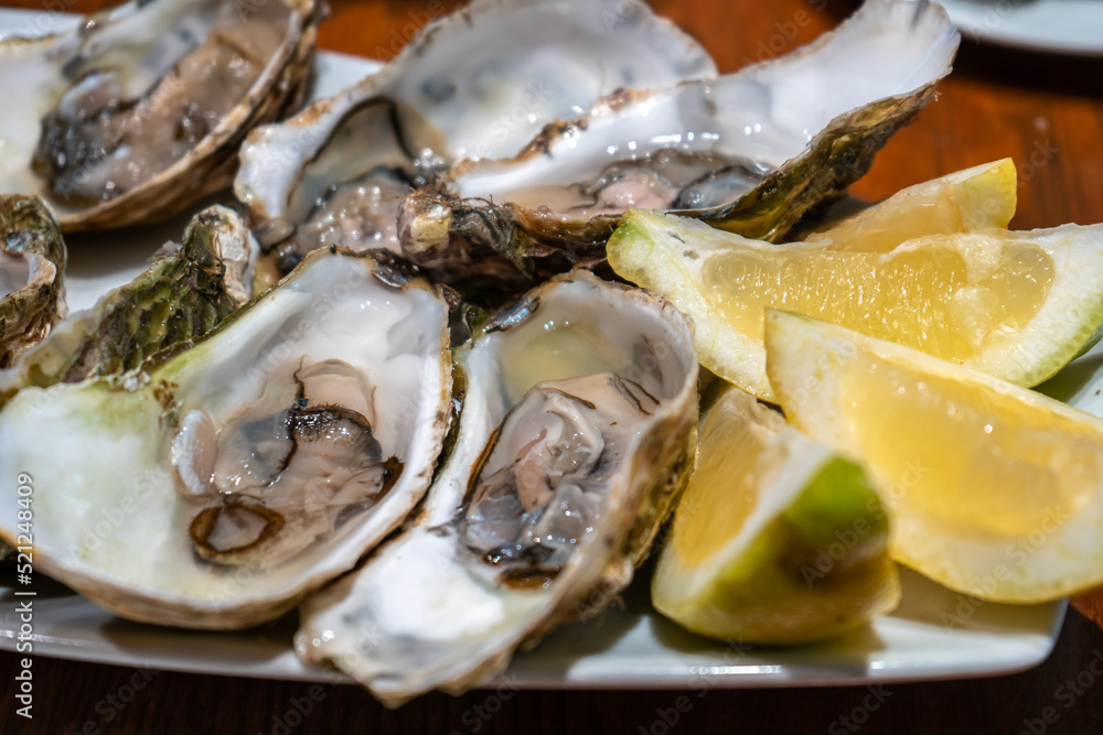 Fresh oysters with ice, lemon on a plate in a restaurant in Barcelona, Spain Fresh oysters with ice, lemon on a plate in a restaurant in Barcelona, Spain