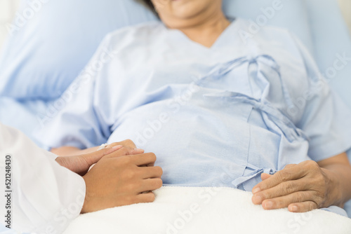 Closeup of hands of nurse and elderly woman. Hands of nurse holding hand of elderly woman on bed at the hospital. People and health care concept © amorn