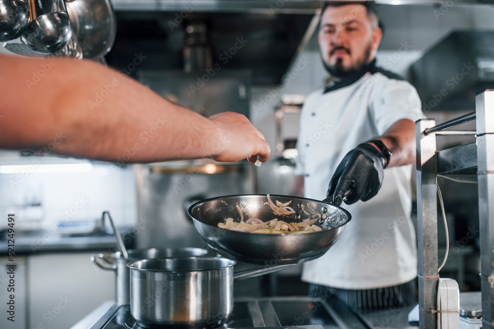 Pouring ingredients. Professional chef preparing food in the kitchen Pouring ingredients. Professional chef preparing food in the kitchen