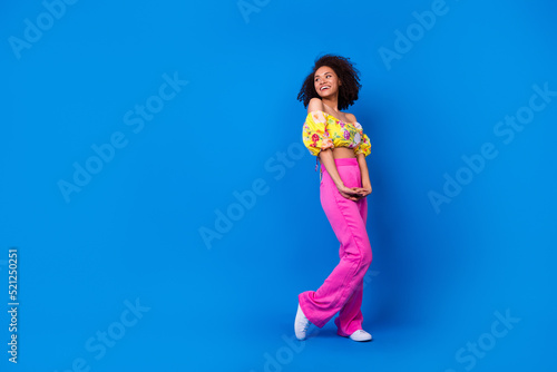 Full length portrait of gorgeous cheerful modest person look empty space isolated on blue color background