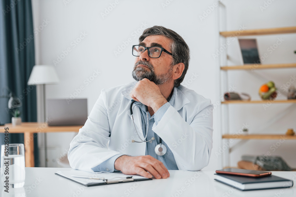 Man sitting and having break. Professional medical worker in white coat is in the office Man sitting and having break. Professional medical worker in white coat is in the office