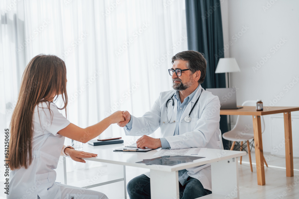 Fototapeta premium Successful agreement between doctor and customer. Professional medical worker in white coat is in the office