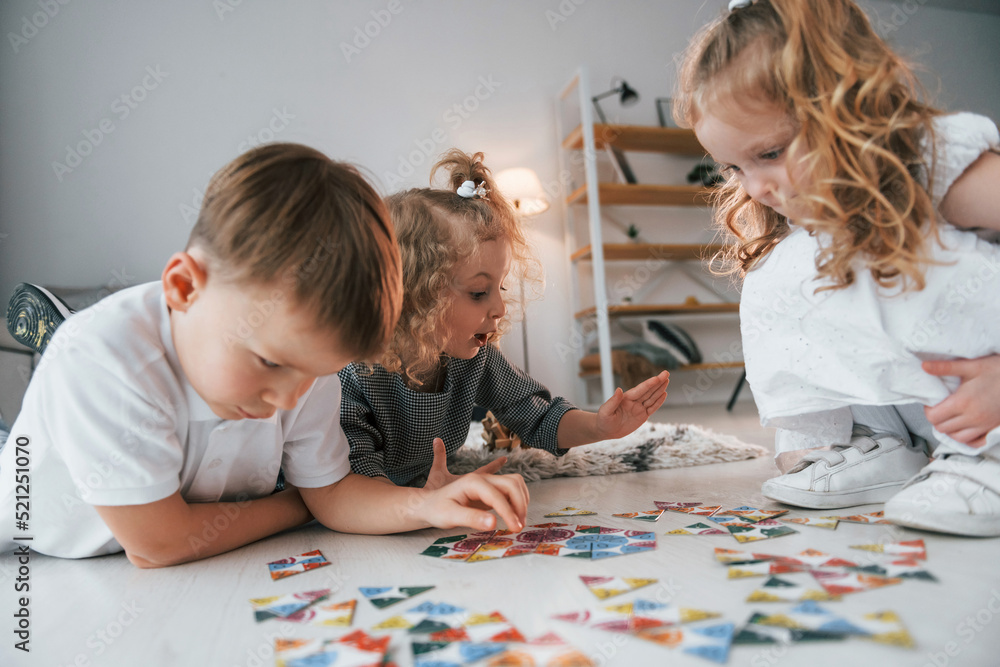 Obraz premium Playing puzzle game. Group of children is together at home at daytime