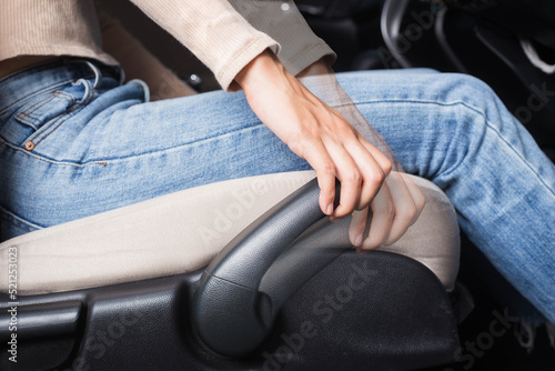 The woman sets up a car driving position. Ergonomic expert adjustment of the driver's seat.