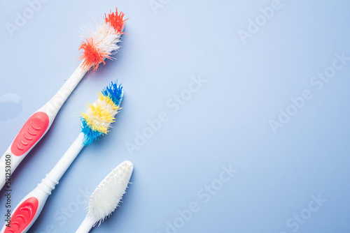 Used old toothbrush on blue background. Dental care concept. copy space photo