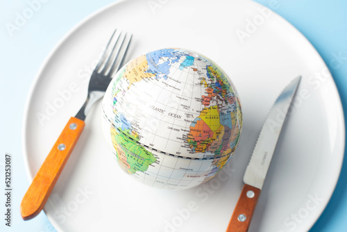 Wallpaper Mural Globe on a plate with fork and knife on a light background, world food day concept Torontodigital.ca