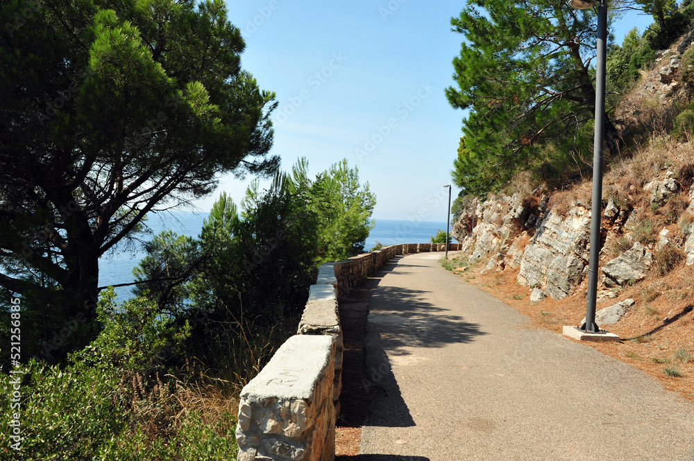 Empty walking path near Petrovac, Montenegro. View toward the Adriatic Sea. Horizontal photo. Empty walking path near Petrovac, Montenegro. View toward the Adriatic Sea. Horizontal photo.