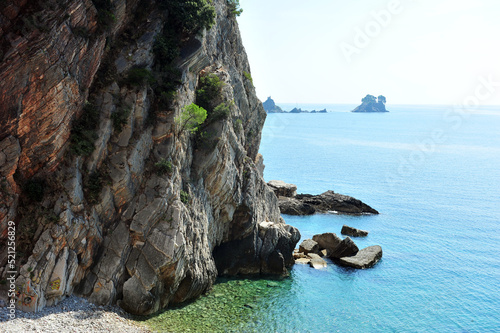 Cliff side rocks with vegetation near Adriatic ocean in Montenegro. Islands Katic and Sveta Nedelja visible in the background. High key effect. photo