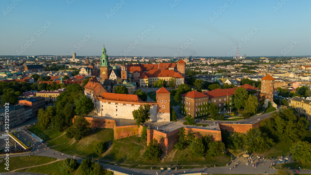 Poland. Krakow skyline with Wawel Hill, Cathedral, Royal Wawel Castle, defensive walls,Vistula riverbank, park, promenade, walking people. Old city in the background