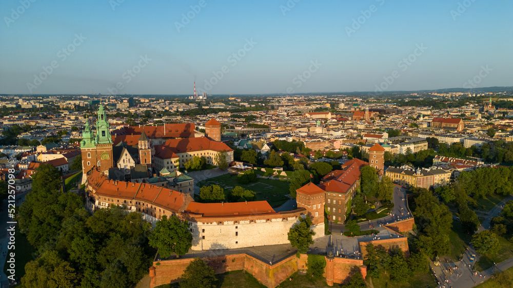 Fototapeta premium Poland. Krakow skyline with Wawel Hill, Cathedral, Royal Wawel Castle, defensive walls,Vistula riverbank, park, promenade, walking people. Old city in the background