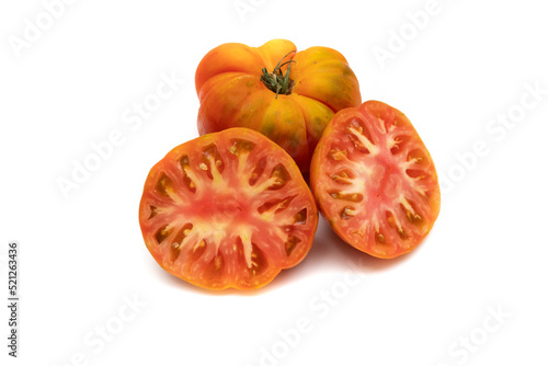One whole raf tomato and two halves  isolated on white background. Production focuses on winter and early spring  which are the most suitable times for consumption.