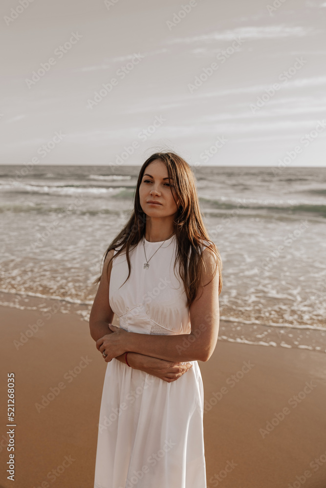 Calm young woman looking away pensively on sandy seashore Calm young woman looking away pensively on sandy seashore