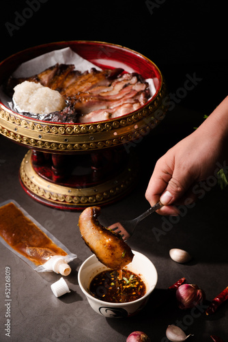 Schilderij op canvas Close up fork pick up and dip a piece of grill pork jowl in spicy sauce thai foo
