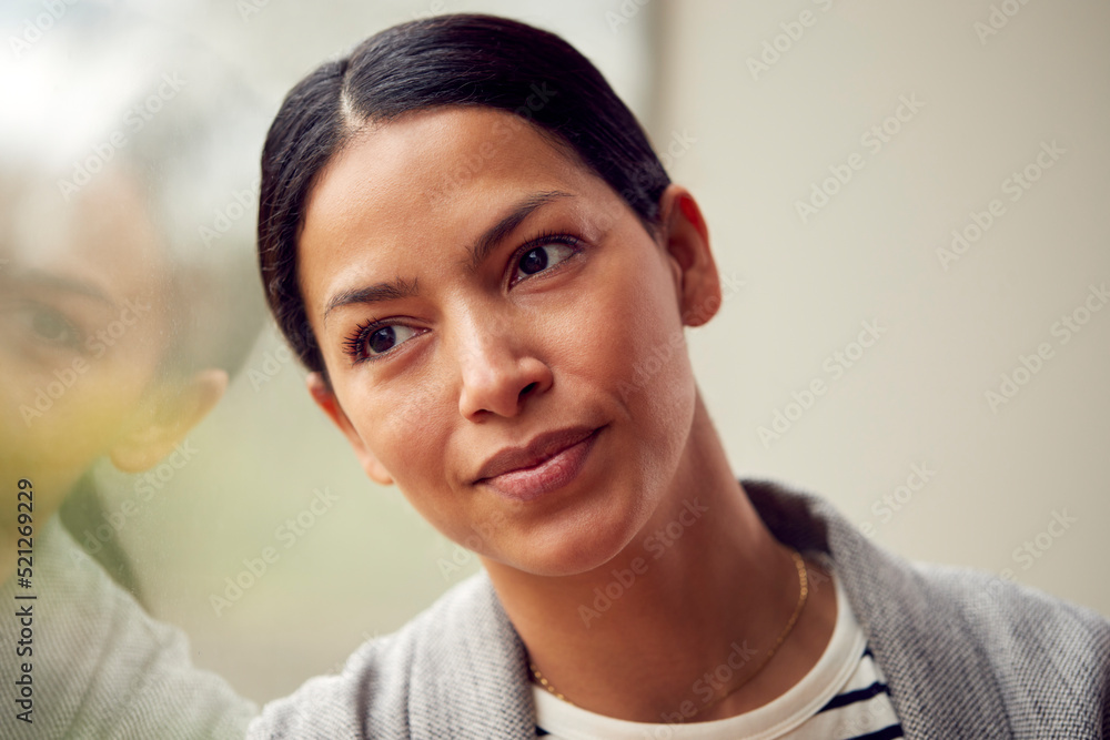 Head And Shoulders Portrait Of Woman Or Businesswoman Standing By Window In Office Or At Home Head And Shoulders Portrait Of Woman Or Businesswoman Standing By Window In Office Or At Home