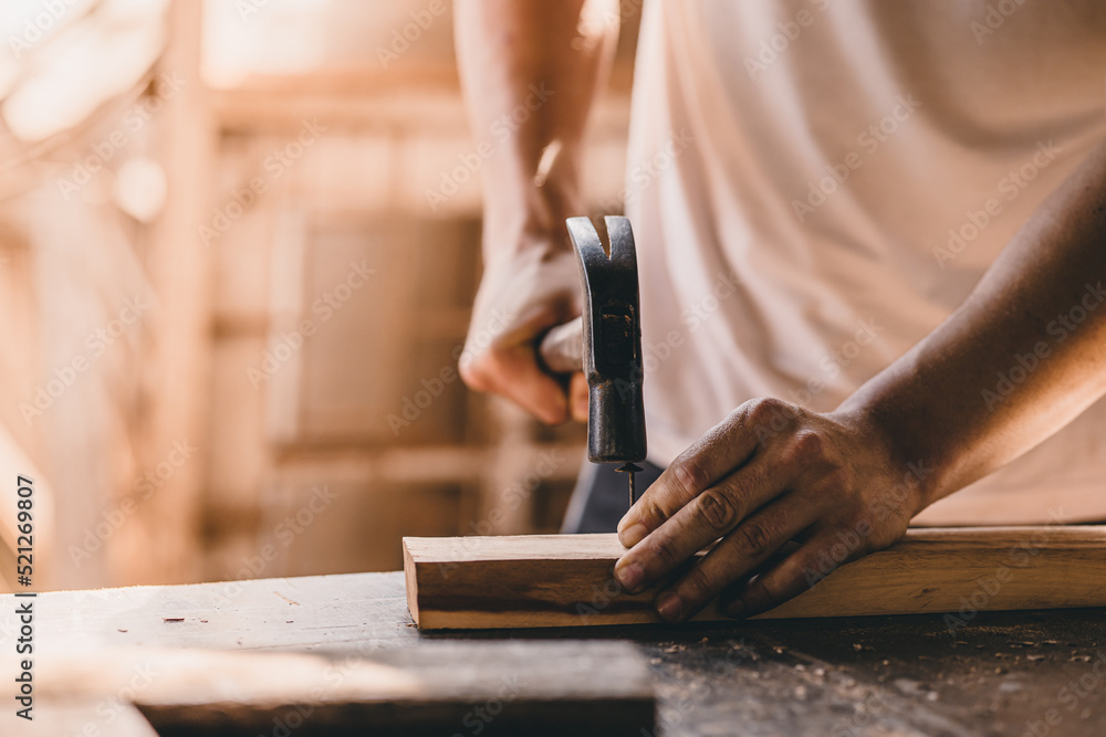 builder wood worker hammer on nails into the wood. construction build renovate and danger at work concept. builder wood worker hammer on nails into the wood. construction build renovate and danger at work concept.