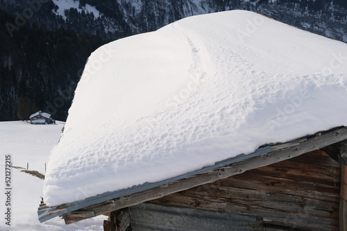 Εκτύπωση καμβά white snowdrift on the slope of a wooden roof, beautiful white landscape, danger