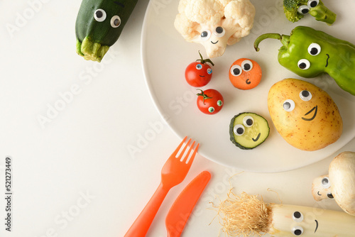 Background with funny vegetables plate served for children on table photo