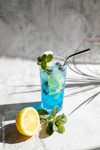 Bild auf Leinwand Refreshing blue curacao cocktail garnished with mint and a slice of lemon