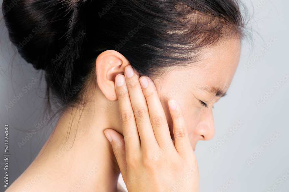 Asian woman suffering from earache. Symptoms of acute external otitis media. Health care concept. Asian woman suffering from earache. Symptoms of acute external otitis media. Health care concept.