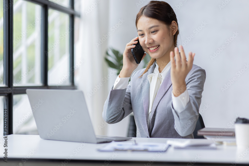 Asian businesswoman talking on phone, using laptop, looking at screen, entrepreneur manager consulting client by call, looking at computer screen, discussing project, reading information Asian businesswoman talking on phone, using laptop, looking at screen, entrepreneur manager consulting client by call, looking at computer screen, discussing project, reading information