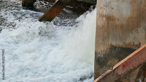 water breaks through a village dam in a crack, on a small river, selective focus.