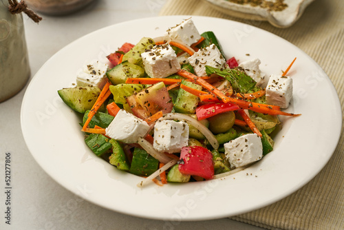 Greek Salad with cucumber  tomato  carrot served in a dish isolated on grey background side view of healthy food