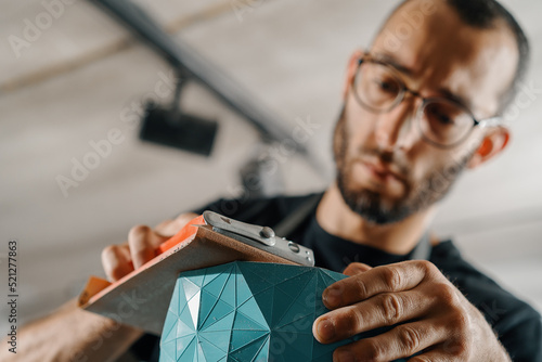 Принти на полотні Close-up: artisan sculptor artist man works with sandpaper.