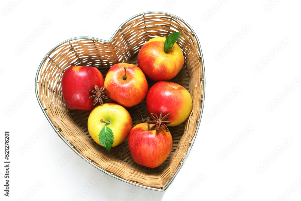 Red apples in straw basket made in the shape of heart on white background. Religious holidays concept - Jewish New Year or Apple spas. Red apples in straw basket made in the shape of heart on white background. Religious holidays concept - Jewish New Year or Apple spas.