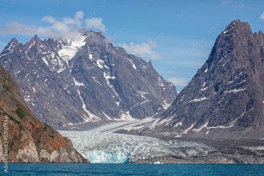Large glacier flowing down mountain side to the sea at Evighedsfjord, Greenland Large glacier flowing down mountain side to the sea at Evighedsfjord, Greenland