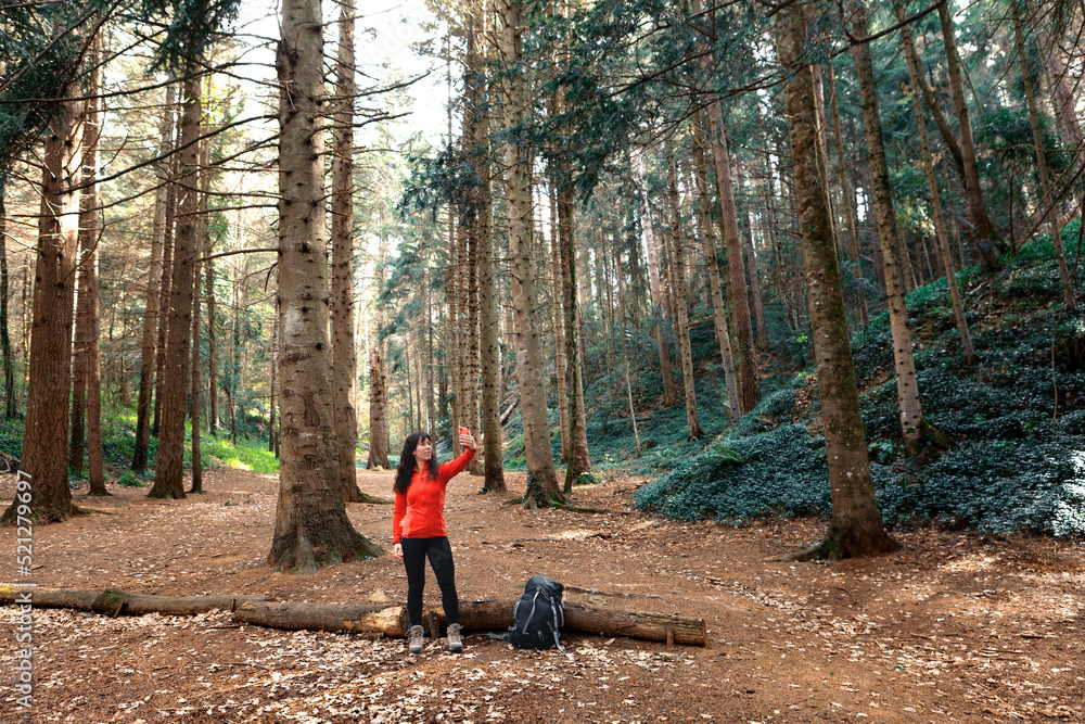 Female hiker taking selfie in forest Female hiker taking selfie in forest