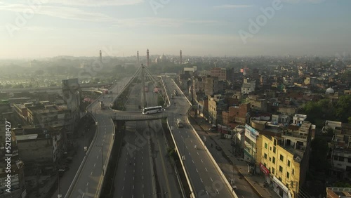 Drone slowly panning over recently built Aazadi Chowk interchange. Historical landmarks including Badshahi Mosque and Lahore fort can also be seen in the background. Early morning capture, RAW footage photo