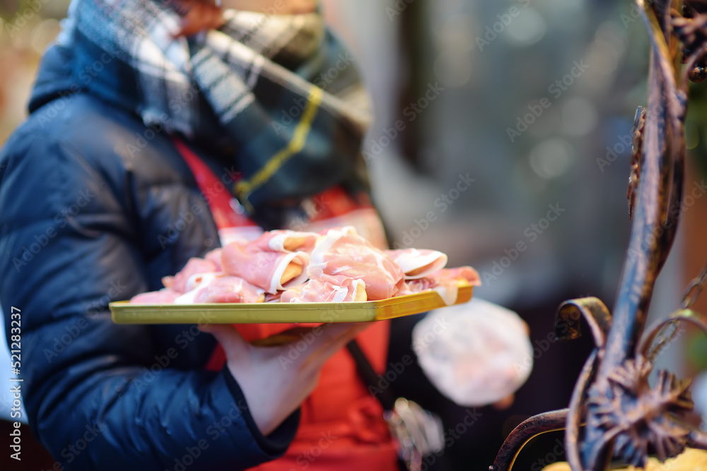 Traditional Poland street food oscypek is a grilled cheese of salted sheep milk with different ingredients as bacon or jams. Cooking of oscypek on Christmas market in Krakow.