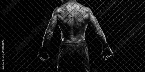 Black and white image of a man in a boxing cage. The concept of sports, Muay Thai, martial arts.