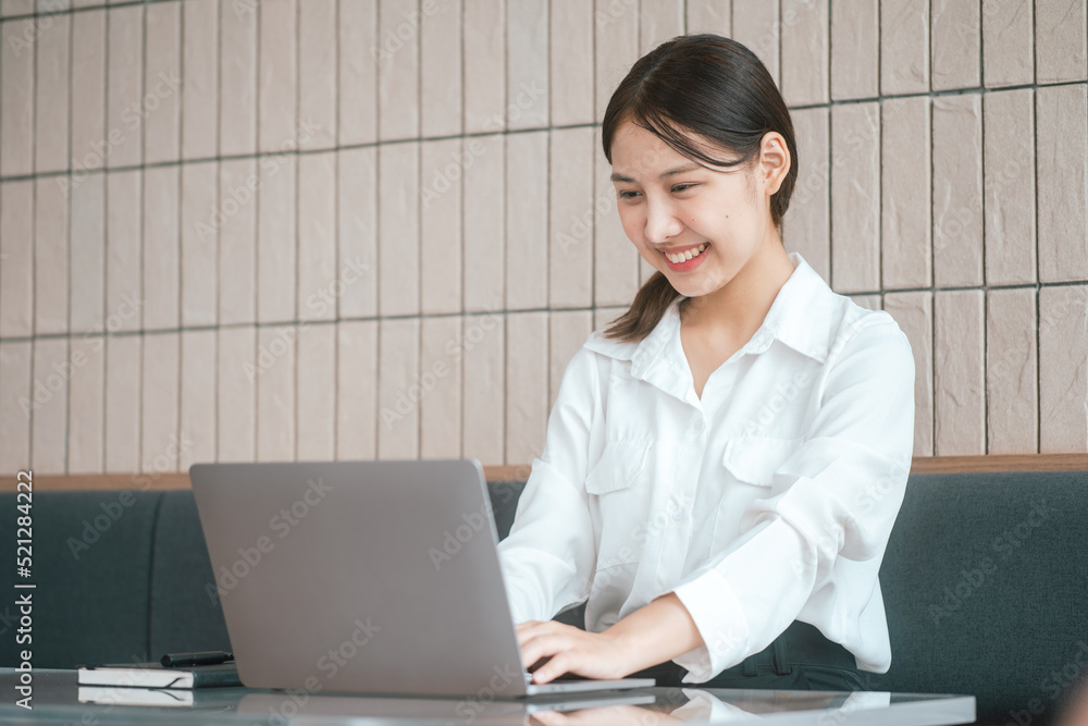 Young business women working and typing on laptop with happy and smile face on office spec. Young business women working and typing on laptop with happy and smile face on office spec.