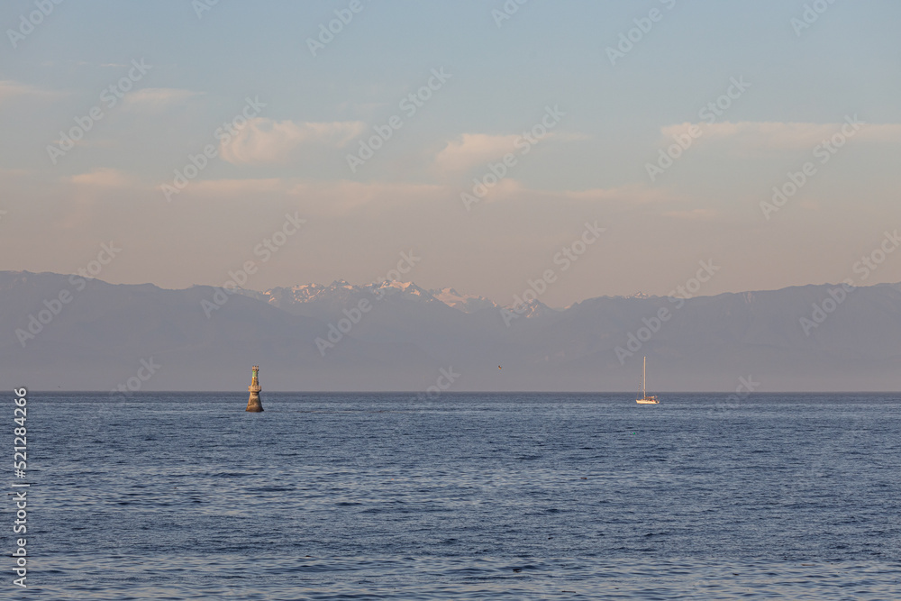 Sailboat silhouetted against the Olympic Mountains of Washington