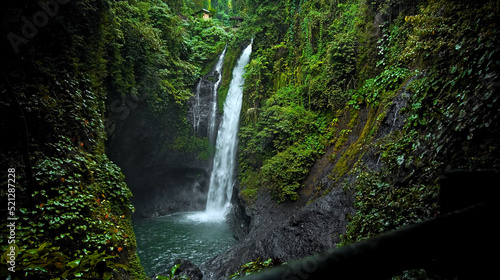 Fototapeta Naklejka Na Ścianę i Meble -  waterfall with rocks among tropical jungle with green plants and trees and water falling down