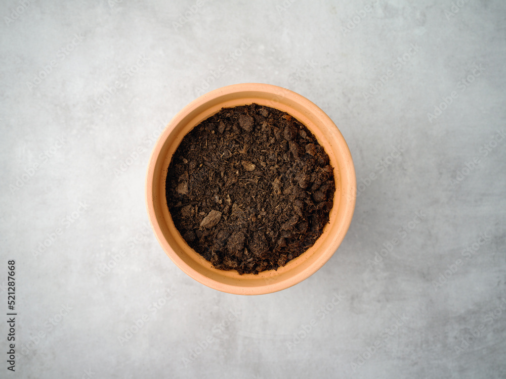 Ceramic flower pot with soil, top view on gray background Ceramic flower pot with soil, top view on gray background