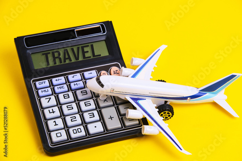 Calculator with inscription travel and white plane yellow background.Concept preparing budget for vacation.
