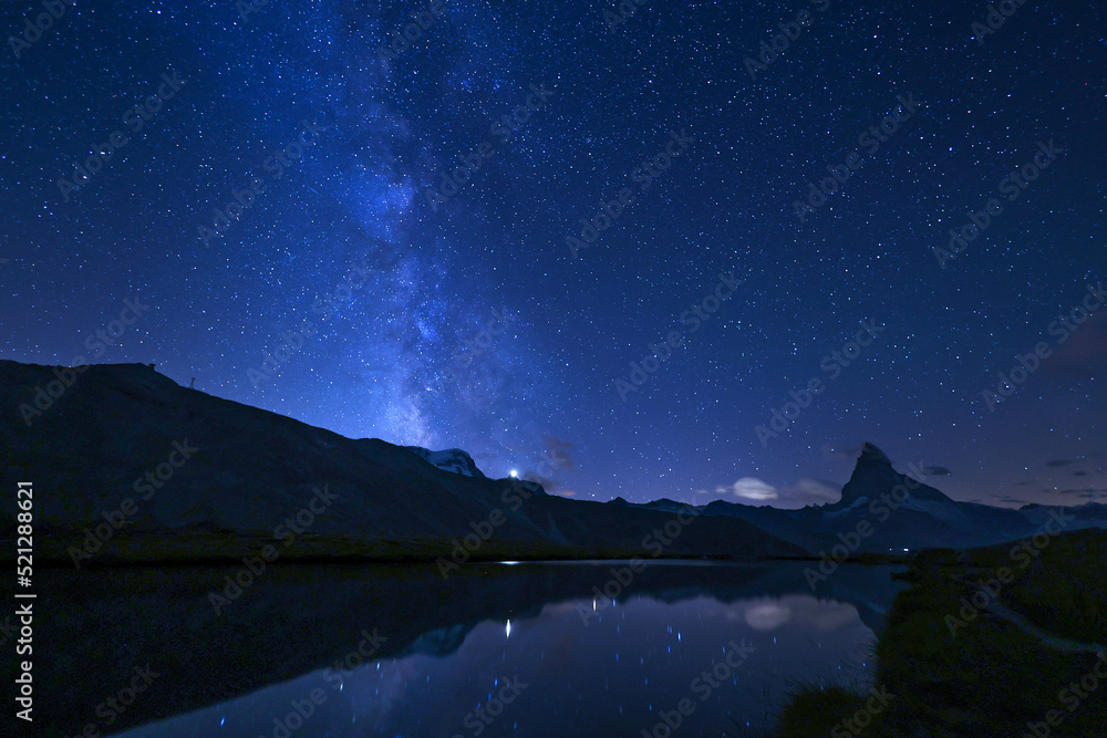 Matterhorn and the milkyway with reflection on the Stellisee lake at summer midnight, Zermatt, Switzerland