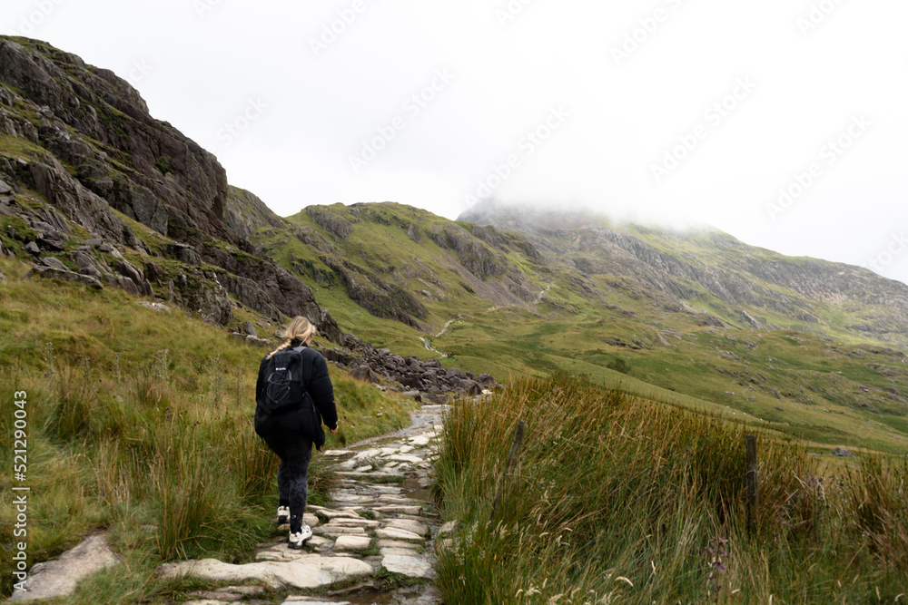 Woman Hiking on Pyg miners track Snowdonia Mountain Snowdonia National Park North wales female .