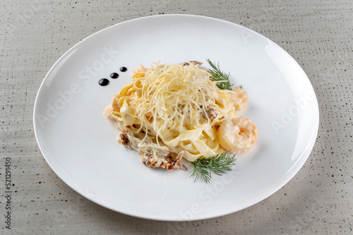 A plate of delicious shrimp alfredo with garlic and cream sauce over pasta.