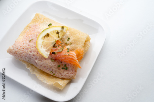 Cuisine of Normandy, galette pancake filled with goat cheese and smoked salmon served with fresh lemon